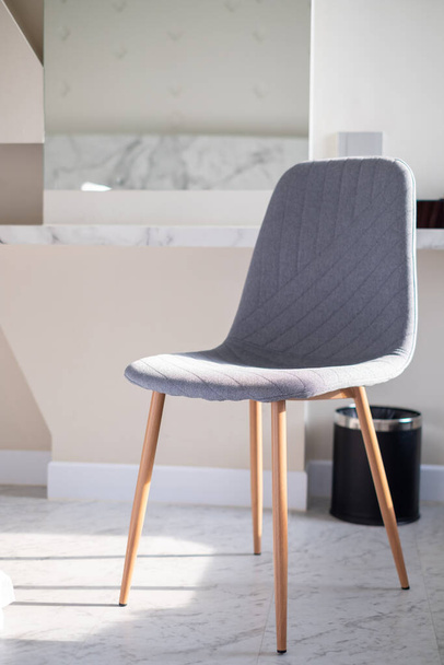Современный роскошный модный стильный стул с белой мягкой тканью на верхней и светлые деревянные ноги стоя, мини-винтажный стиль - Фото, изображение