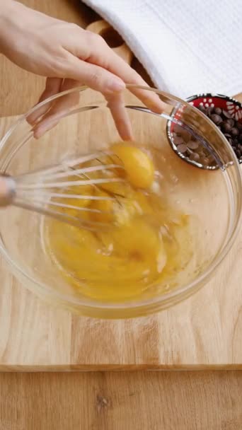 Cucino. Ricette alimentari sane. Sbattere le uova con una frusta. Video verticale - Filmati, video