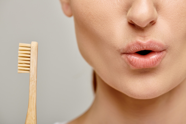 tiro recortado de mulher surpreendida na década de 30 segurando uma escova de dentes de bambu, expressão facial - Foto, Imagem