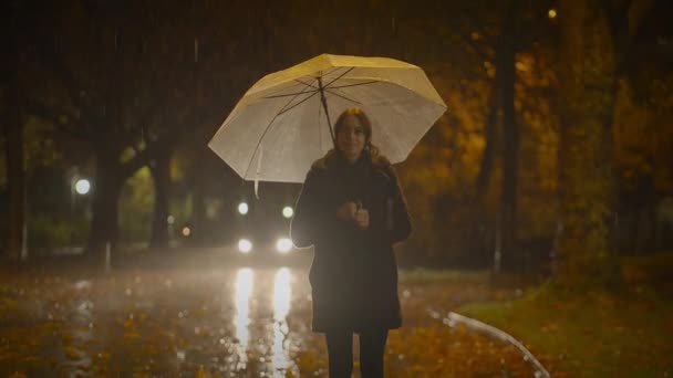 Felice donna spensierata che balla con l'ombrello fuori nella notte di pioggia - Filmati, video