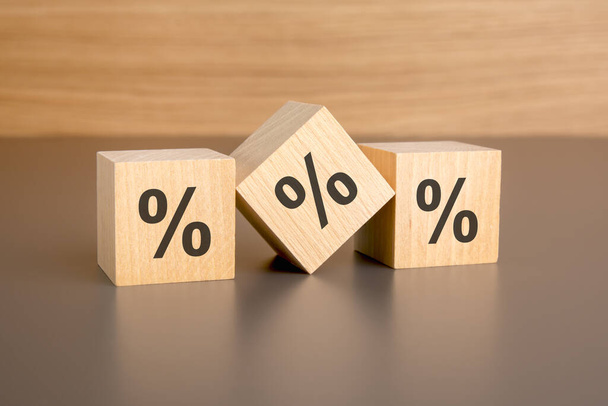 percent sign on wooden blocks against brown background with copy space. concept of sale and discount. - Photo, Image
