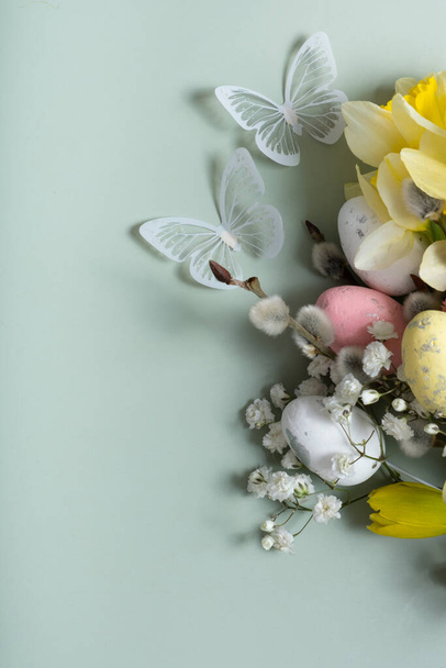 Daffodils, velikonoční vajíčka a vrba na zeleném pozadí s kopírovacím prostorem. Šablona velikonočního přání. - Fotografie, Obrázek