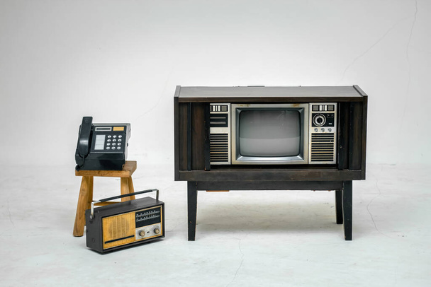 Ретро старый телевизор с вырезанной дорожкой на белом фоне. Телевизор с экраном, винтажным радио и телефоном, технология. - Фото, изображение