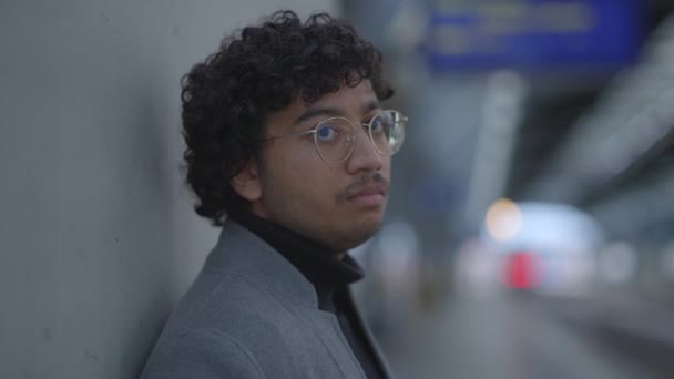 Porträt eines indischen Mannes mit Brille, der im Bahnhof pendelt. Hochwertiges 4k Filmmaterial - Filmmaterial, Video
