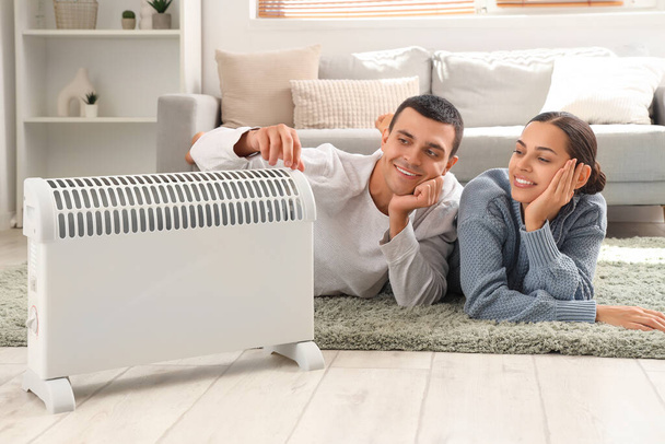 Young couple warming near radiator at home - Photo, Image