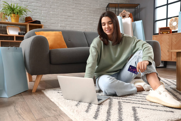Молода жінка з ноутбуком і кредитною карткою Покупки онлайн вдома
 - Фото, зображення