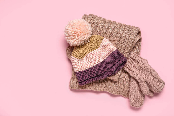 Páros kötött kesztyű meleg kalapban és sál rózsaszín alapon - Fotó, kép