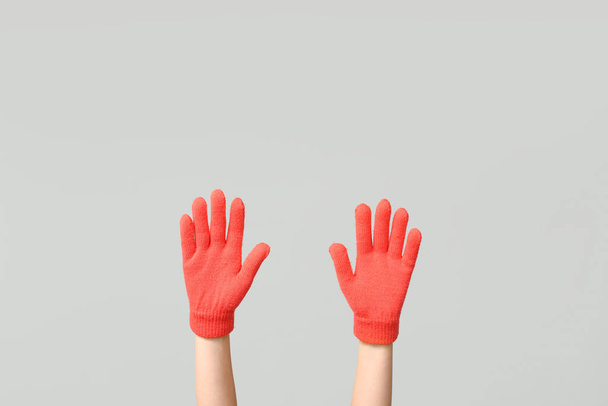 Ręce w ciepłych rękawiczkach na szarym tle - Zdjęcie, obraz