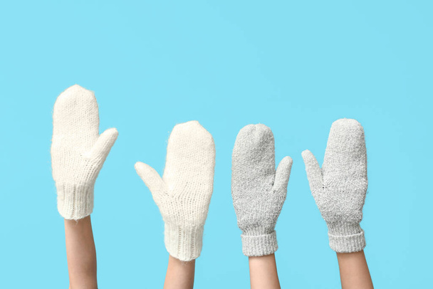 Χέρια σε ζεστά γάντια σε μπλε φόντο - Φωτογραφία, εικόνα
