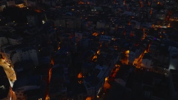 夜の街の上を飛行する. 歴史的な都市地区の建物間の狭い通り. 近代的な高層オフィスビルは遠くにあります. イスタンブール,トルコ. - 映像、動画