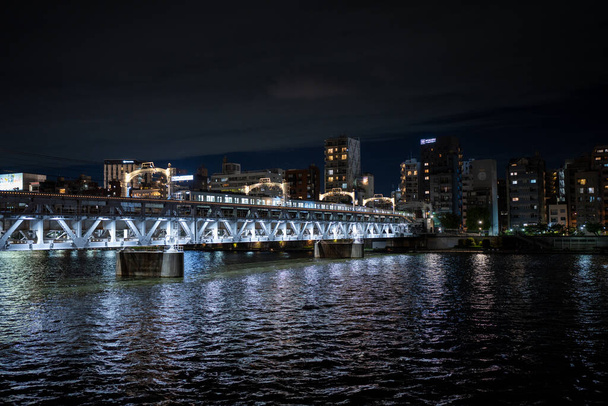 залізничний міст через річку Суміда в Токіо Японія вночі - Фото, зображення