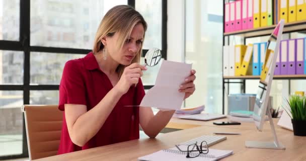 Mujer gerente con mala vista utiliza lupa y lee el documento. Problema de visión y lectura de documentos - Metraje, vídeo