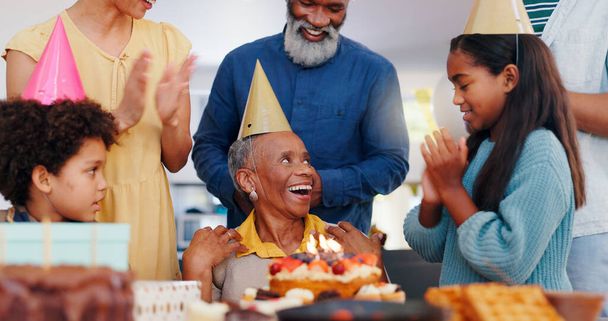 Pastel, feliz y la familia en la fiesta de cumpleaños celebran juntos en la casa moderna con velas. Sonríe, emocionado y niños pequeños con padre africano y abuelos con sombrero de postre dulce en casa - Foto, imagen