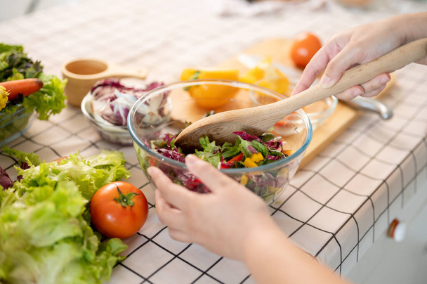 Immagine ravvicinata di una donna che prepara un'insalatiera fresca e salutare per la colazione in cucina. Cucina casalinga, cibo sano, dieta, alta nutrizione - Foto, immagini