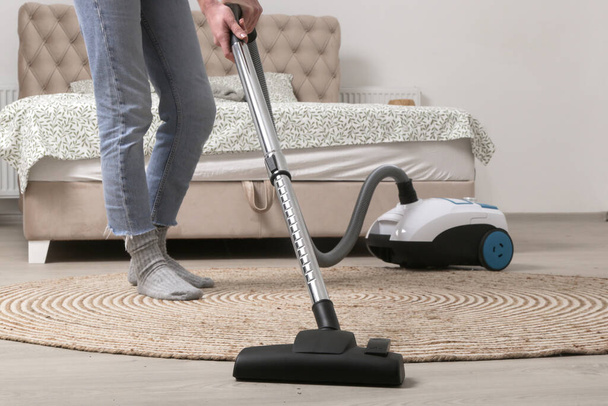 Housewife vacuum uming the room, domestic life, apartment cleaning concept - Фото, изображение