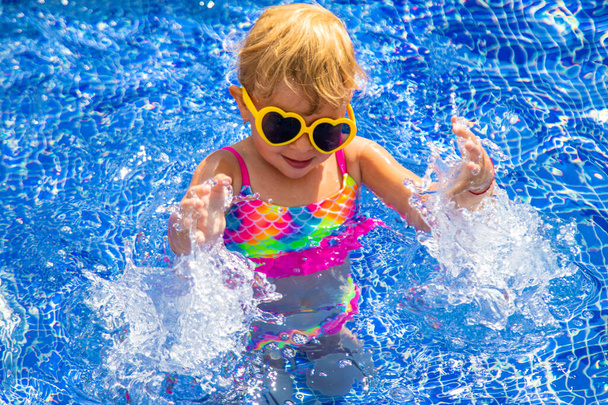 Дитина біля басейну в сонцезахисних окулярах. Вибірковий фокус. Подорожі. - Фото, зображення