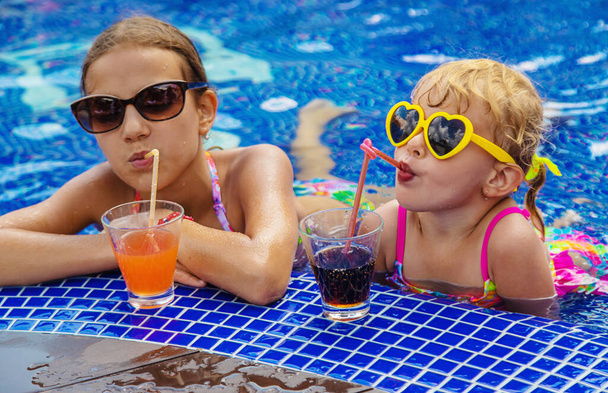 Děti pijí koktejl v bazénu. Selektivní soustředění. Děti. - Fotografie, Obrázek