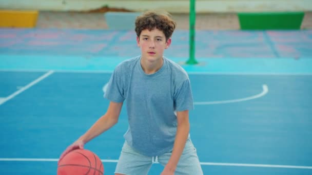 Μπάσκετ σε αργή κίνηση. Αγόρι που προπονείται στο μπάσκετ. Ο έφηβος παίζει μπάσκετ. Υγιεινός τρόπος ζωής και χόμπι. Χαριτωμένο παιδί χτυπάει μπάλα μπάσκετ.. - Πλάνα, βίντεο
