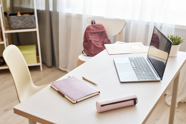 Achtergrond beeld van studenten bureau thuis met open laptop en rugzak, schoolmeisje werkplek, kopieerruimte - Foto, afbeelding
