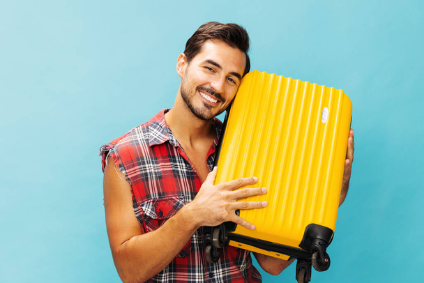 Man utazás nyaralás utazás sárga stúdió háttér poggyász stílus poggyász túra bőrönd másolat boldog fickó űrutazás nyaralás hipster kék életmód repülés utazó jegy hétvége - Fotó, kép