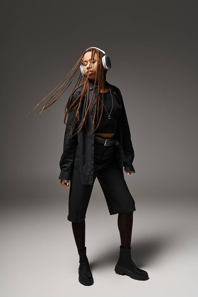 νεαρή Αφροαμερικανή στα 20 με ράστα να ακούει μουσική στα ακουστικά, εκστατικός χορός - Φωτογραφία, εικόνα