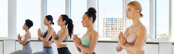striscione di cinque giovani donne multiculturali con mani di preghiera che praticano yoga in studio luminoso - Foto, immagini