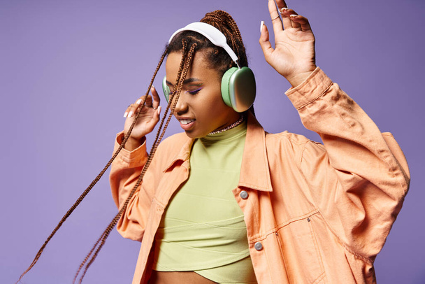 pleased african american girl in 20s listening music in wireless headphones, moving to rhythm - Photo, Image