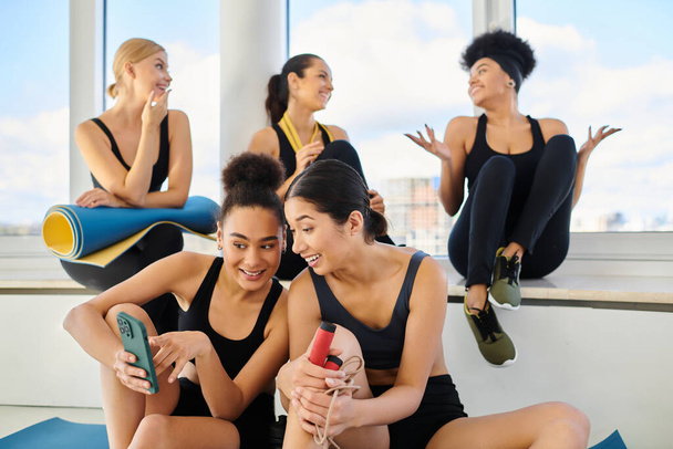 ryhmä iloinen viisi naispuolista ystävää urheiluvaatteissa chattailu harjoittelun jälkeen pilates-studiossa - Valokuva, kuva