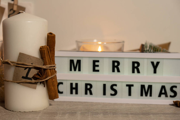 Kaarsen met adventskalender Lightbox met tekst MERRY CHRISTMAS Traditionele Brandende Kerstkaarsen met nummers die aftellen voor Kerstmis. Mooie Advent thuis. Feestelijke kaarslicht en - Foto, afbeelding