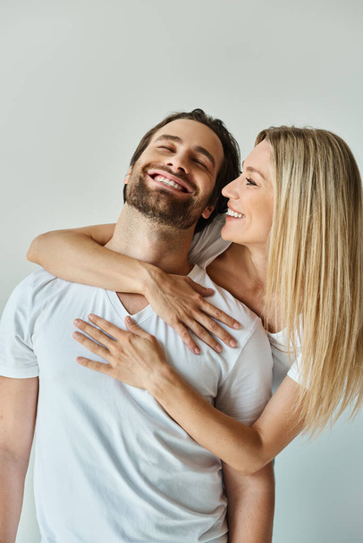 Ένας άντρας και μια γυναίκα μοιράζονται μια ζεστή, παθιασμένη αγκαλιά, εκφράζοντας βαθιά αγάπη και σύνδεση.. - Φωτογραφία, εικόνα