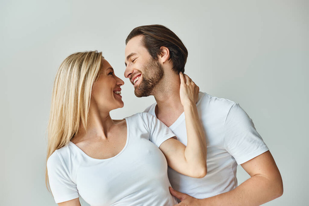 Мужчина и женщина тепло улыбаются друг другу в момент, наполненный романтикой и общением. - Фото, изображение
