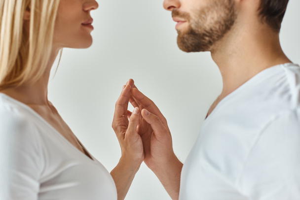 Un hombre y una mujer se miran a los ojos, expresando una conexión profunda y apasionada en un momento íntimo. - Foto, Imagen