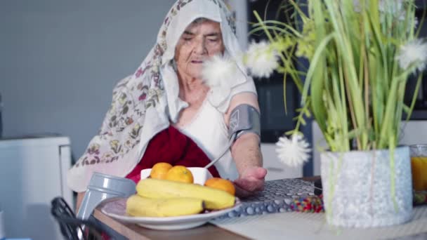 Yaşlı Müslüman bir kadın kendini kötü hissettiğinde tansiyonunu ölçer. - Video, Çekim