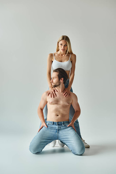 A man sits atop a woman on his back, showcasing a dynamic and intimate moment between the sexy couple. - Photo, Image