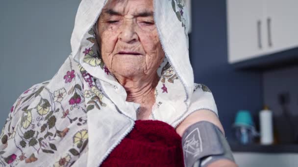Muslimische ältere Frau nimmt ihren Blutdruck, wenn es ihr schlecht geht - Filmmaterial, Video