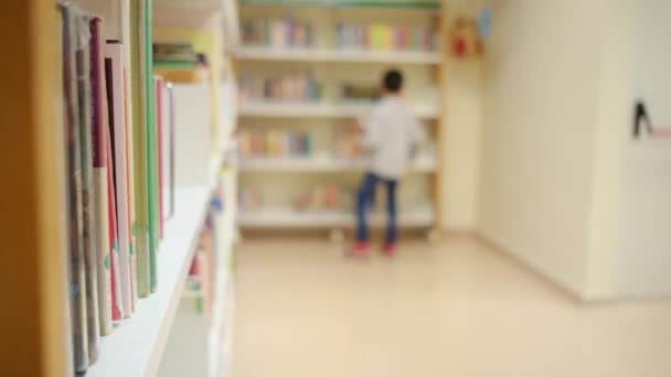 fiatal fiú a könyvtárban az iskolában - Felvétel, videó