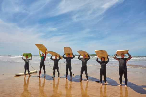 Un groupe de jeunes surfeurs dynamiques saisit un moment collectif avec leurs planches au bord de l'océan à Essaouira, au Maroc. La camaraderie de la culture surf sur fond de charme côtier pittoresque d'Essaouira - Photo, image