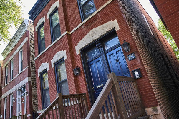 Image de la vue inclinée de la vieille maison en brique rouge avec portes noires, menaçante, hantée, maléfique, financière, hypothécaire - Photo, image