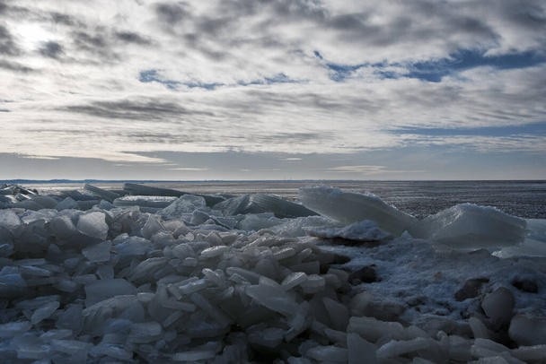 Льодяні грози на зимовому морському пляжі, сонячне світло пробивається крізь хмари, підсвічування - Фото, зображення