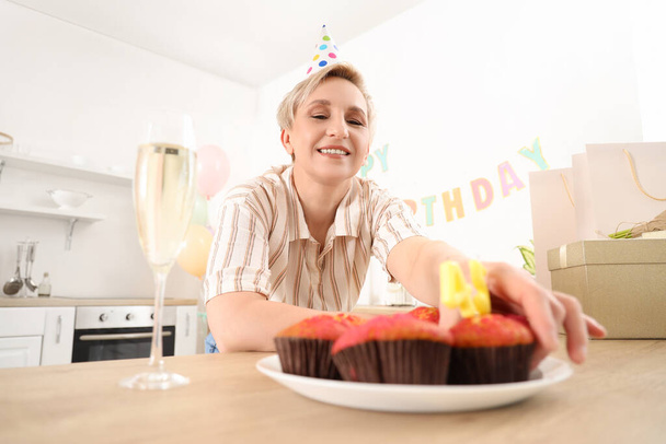 Starší žena slaví své narozeniny v kuchyni - Fotografie, Obrázek