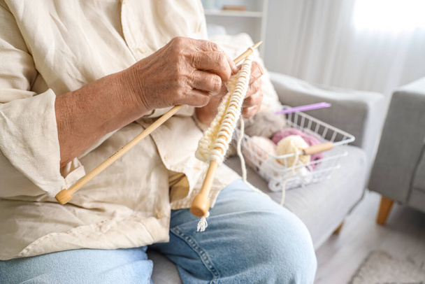 Senior woman knitting on sofa at home, closeup - Photo, Image