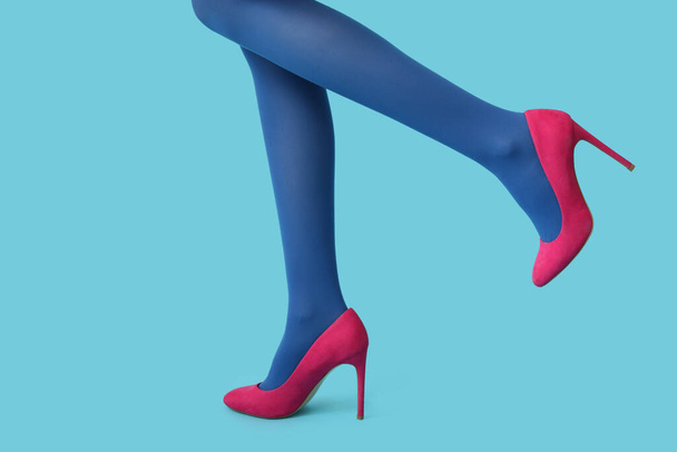 Legs of beautiful young woman in stylish high heels on blue background - Photo, Image