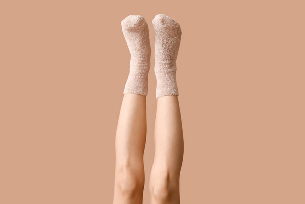 Nogi młodej kobiety w ciepłych skarpetkach na beżowym tle - Zdjęcie, obraz