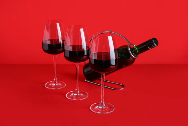 Bouteille et verres de vin rouge sur fond de couleur - Photo, image