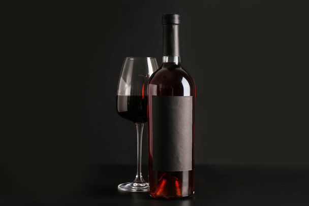 Palack és üveg vörösbor fekete alapon - Fotó, kép