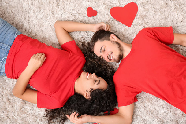 Junges Paar mit roten Herzen zum Valentinstag zu Hause - Foto, Bild