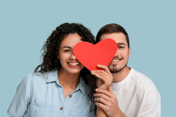 Mladý pár s papírovým srdcem na Valentýna na modrém pozadí - Fotografie, Obrázek