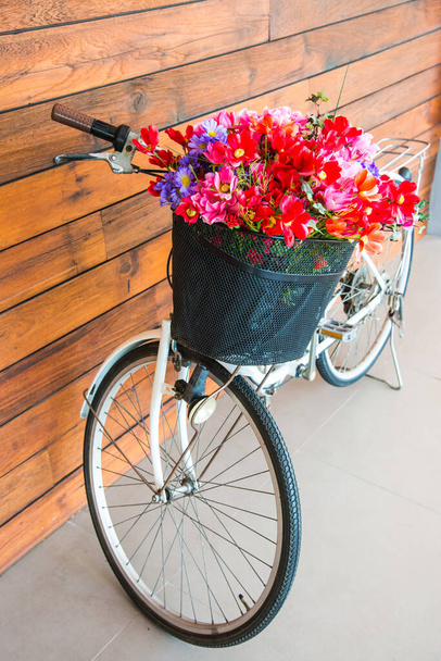 Vintage fiets met bloem in mandje, Thailand. - Foto, afbeelding