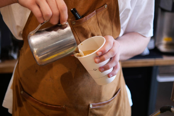  Kahve makinesi köpüren süttür. Baristaların elleri bir sürahi sütü tutar - Fotoğraf, Görsel