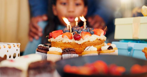 З днем народження, тортом та свічкою на святкуванні з сім'єю для вечірки, свята або особливого дня вдома. Крупним планом маленька дівчинка дме полум'я за бажання зростання, любові або догляду і зв'язування в будинку. - Фото, зображення